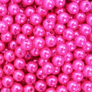 Macro shot of bright pink ABS acrylic pearl beads with threading holes for DIY jewelry making