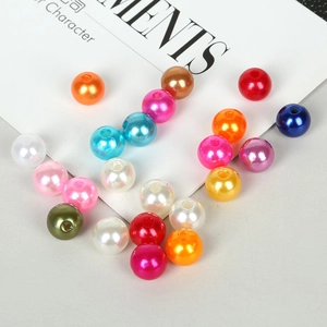 Close-up of colorful round acrylic pearls with pre-drilled holes for DIY jewelry making