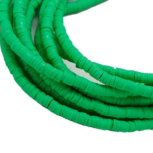 Gros plan de perles heishi plates vert herbe pour la fabrication de bracelets DIY