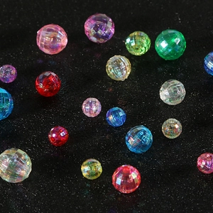 Colorful faceted acrylic beads for DIY jewelry making on a sleek black background