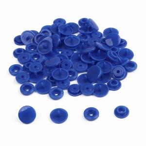 Detail view of 4-piece dark blue resin snap fastener set with loose pieces on white background
