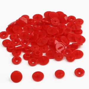 Detail view showing four components of a bright red plastic resin snap fastener