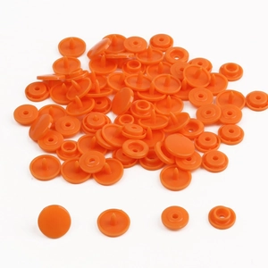 Detailed close-up showing four components of a bright orange resin snap fastener set