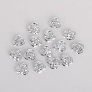 Detailed view of three-dimensional silver metal rose beads for DIY jewelry making