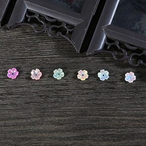 Detalle de cuentas de flores de resina aurora para horquillas DIY sobre madera