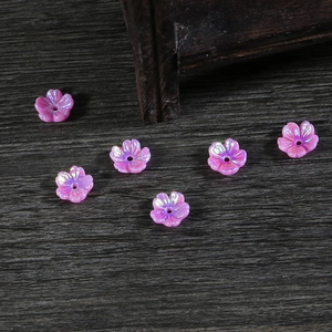 Vista macro de cuentas de resina con forma de flor nacarada para joyas artesanales