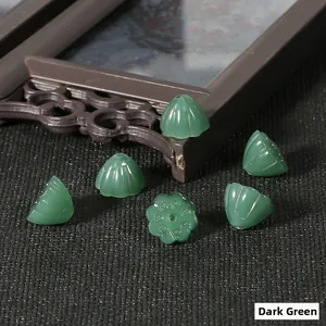 Dettaglio di perline a loto verde scuro su tessuto nero per accessori capelli fai-da-te