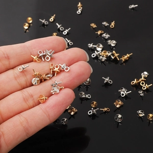 Hand holding gold and silver eye pin bails with cup peg for DIY pearl pendant jewelry making