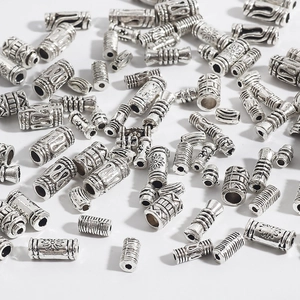 Macro detail of vintage alloy cylindrical spacer beads with intricate sun and weave patterns