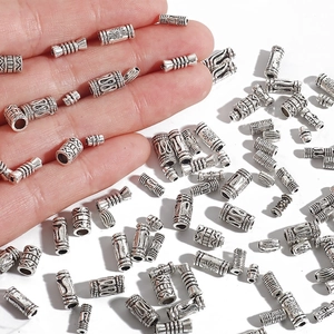 Macro detail of antique silver cylinder beads with embossed patterns for DIY jewelry
