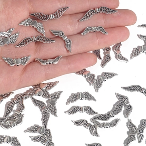 Pendentifs ailes de cœur en alliage argenté antique pour bijoux DIY présentés sur main