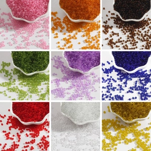 Macro shot of 2-3mm colorful glass seed beads in nine assorted shades for jewelry DIY