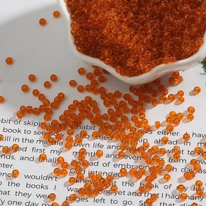 Macro shot of transparent orange glass seed beads for DIY jewelry and handmade crafts
