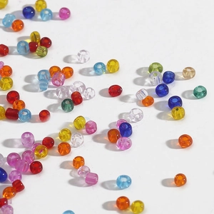 Colorful 2-4mm transparent glass seed beads scattered on white background for DIY jewelry