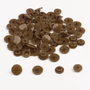 Detailed macro view of brown resin snap fasteners for children's clothing DIY sets