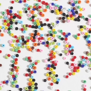 Colorful assorted glass seed beads for DIY jewelry making scattered on white background