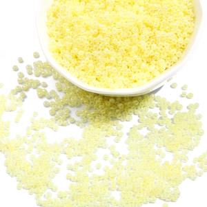 DIY lemon yellow glass seed beads for handmade jewelry in a white ceramic bowl