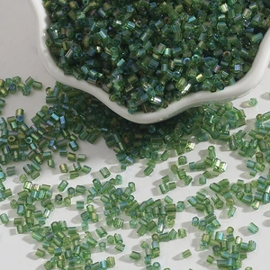 Macro detail of 2mm emerald green glass bugle beads with iridescent AB coating for DIY