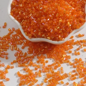 Macro detail of 2mm orange translucent bugle beads for DIY jewelry and handicraft making