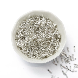 High-shine silver twisted glass bugle beads in a ceramic bowl for DIY jewelry making