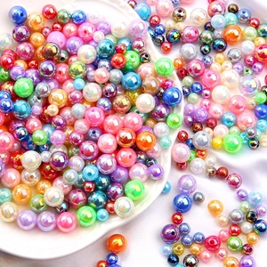 Colorful AB iridescent acrylic pearls for DIY jewelry making displayed on white silk fabric