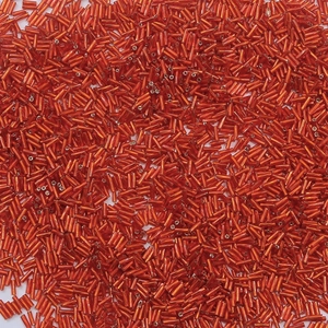 Macro shot of red metallic glass bugle beads for DIY jewelry and necklace crafting