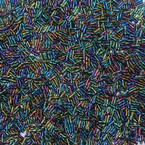 Detailed macro view of colorful iridescent glass bugle beads for DIY jewelry making