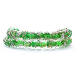 Detail of faceted green glass wheel beads with gold foil and sand swirls for jewelry