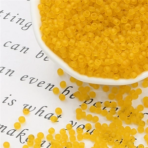 Macro shot of matte yellow glass seed beads for DIY jewelry and handmade crafts