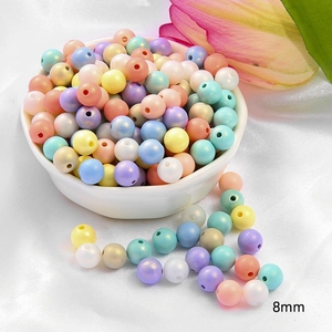 Detail of 8mm macaron acrylic beads in a ceramic bowl for DIY jewelry making and crafts