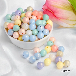 Macro shot of 10mm colorful acrylic pastel beads for DIY jewelry making in a white bowl