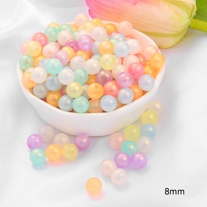 Detailed macro view of 8mm acrylic pastel beads in a ceramic bowl for DIY jewelry making