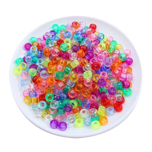 Macro detail of colorful translucent pony beads in a white bowl for DIY bracelet crafting
