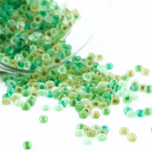 Detailed macro view of assorted green matte frosted glass seed beads for DIY jewelry making
