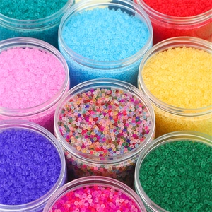 Macro shot of assorted colorful frosted translucent seed beads in clear plastic jars