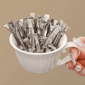 Silberne Metall-Haarklammern für Volumen und Styling in einer Keramiktasse