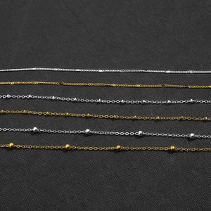 Detail of assorted gold and silver iron O-chains with bead accents for DIY jewelry making