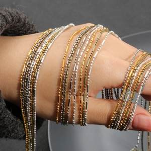 Close-up of gold and silver bamboo bead iron chains wrapped around hand for DIY jewelry