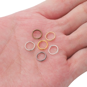 Macro-opname van diverse metalen dubbele ringetjes voor sieraden op de handpalm