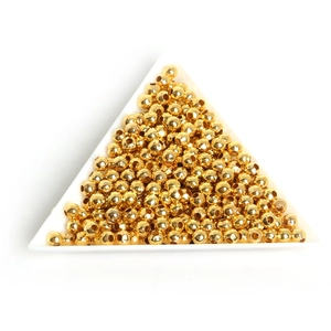 Detailed macro view of golden metal spacer beads for DIY jewelry in a white tray