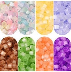 Macro detail of 2.5mm cat eye cylindrical beads in various matte translucent colors for DIY