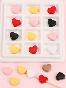 Gros plan de perles de cœur en acrylique colorées avec trou pour création de bijoux