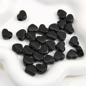 Détail de perles de cœur en acrylique noir poli pour bijoux et colliers artisanaux