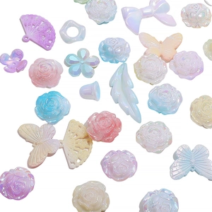 Detailed macro view of assorted macaron acrylic beads in floral and butterfly shapes