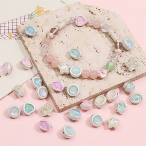 Close-up of pastel star and heart beads with iridescent finish for DIY jewelry