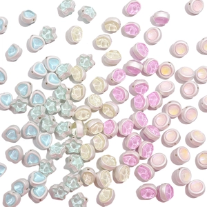 Macro view of pastel alloy beads with star and heart shapes for DIY jewelry making