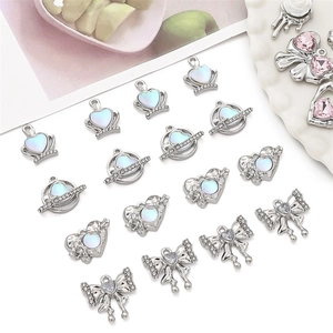 Detailed macro view of alloy heart and planet pendants with opal stones for DIY jewelry