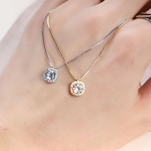 Detail of silver and gold square halo pendant necklaces on delicate box chains