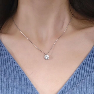 Close-up of S925 sterling silver halo necklace with a round-cut stone on a model
