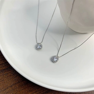 Macro shot of S925 sterling silver square halo pendant with cubic zirconia on a white plate